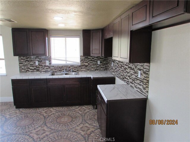 kitchen featuring backsplash, tile countertops, and sink