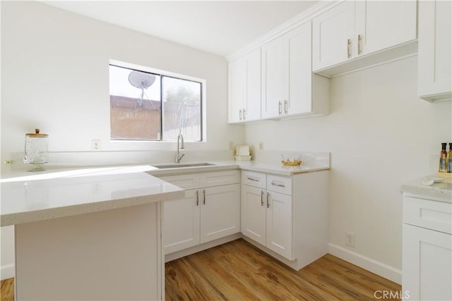 kitchen featuring light hardwood / wood-style flooring, white cabinets, and sink