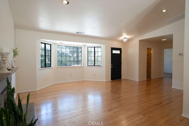 unfurnished living room with lofted ceiling and light hardwood / wood-style floors