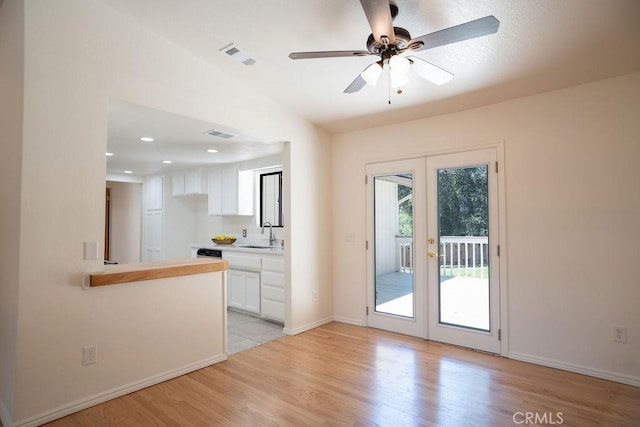 entryway with sink, vaulted ceiling, ceiling fan, and light wood-type flooring