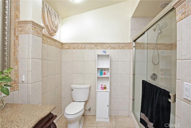 bathroom with toilet, tile patterned flooring, a shower with door, and tile walls