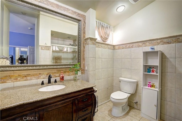 bathroom featuring tile walls, vanity, tile patterned flooring, and toilet