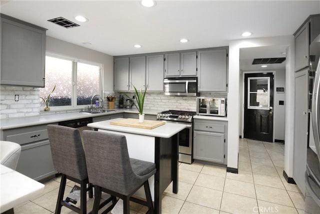 kitchen with appliances with stainless steel finishes, sink, and gray cabinetry