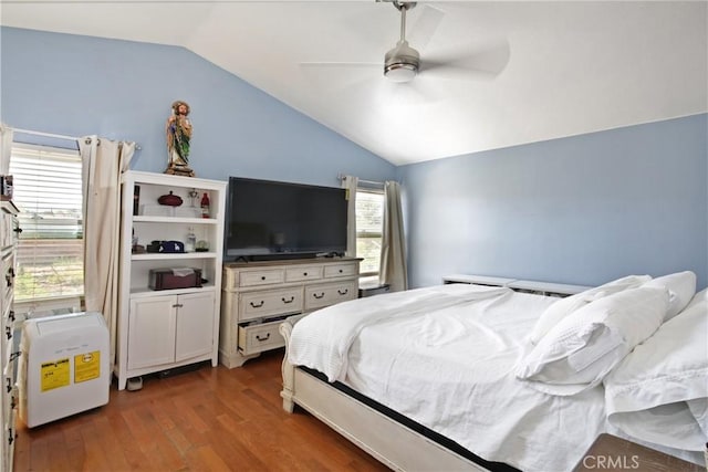 bedroom with dark hardwood / wood-style flooring, vaulted ceiling, and ceiling fan