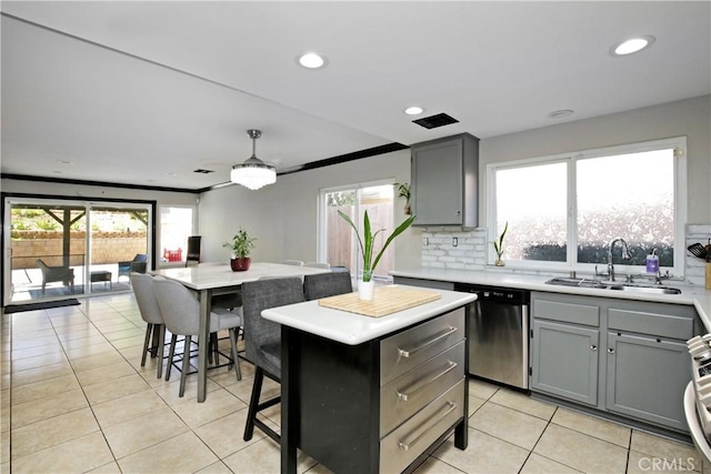 kitchen featuring a kitchen island, tasteful backsplash, sink, a kitchen bar, and stainless steel dishwasher