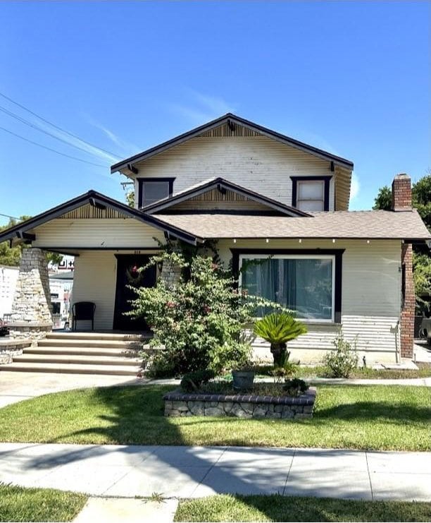 view of front of property featuring a front yard and a carport