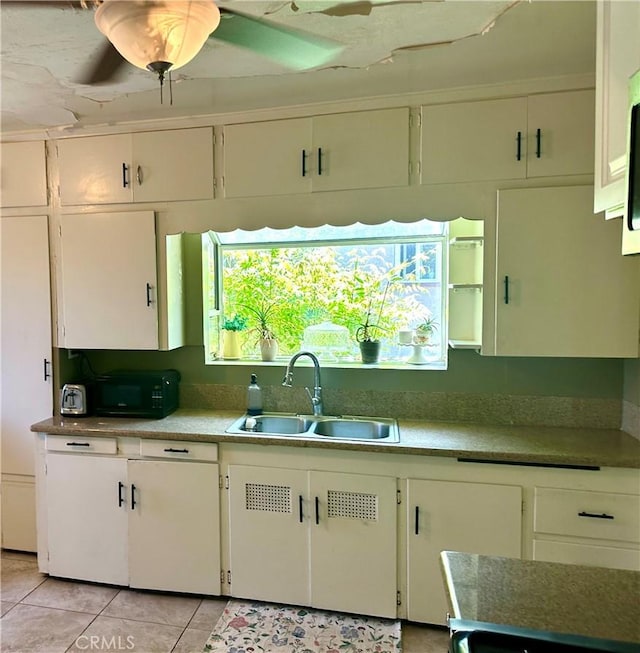 kitchen with white cabinets, light tile patterned floors, a healthy amount of sunlight, and sink