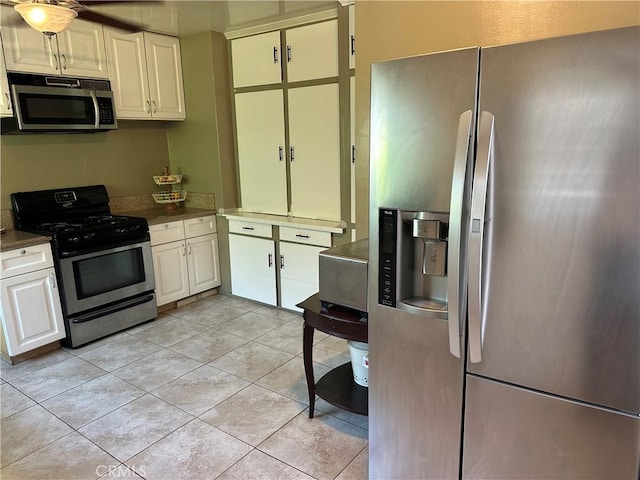 kitchen featuring white cabinets, stainless steel appliances, and light tile patterned flooring