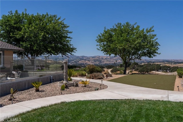 view of community featuring a mountain view and a yard