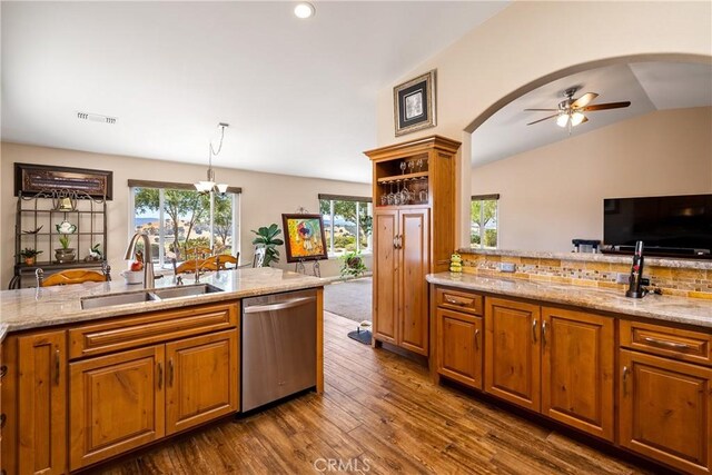 kitchen featuring lofted ceiling, dark wood-type flooring, sink, hanging light fixtures, and stainless steel dishwasher