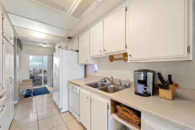 kitchen with light tile patterned floors, white cabinetry, sink, and white dishwasher