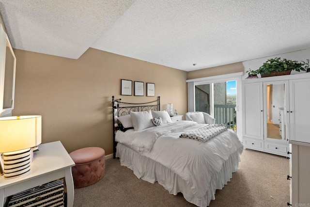 bedroom with a textured ceiling, light colored carpet, and access to exterior