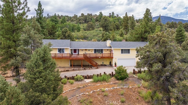 back of house featuring a garage and a deck with mountain view