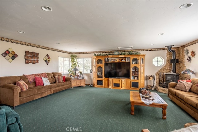 carpeted living room with a wood stove