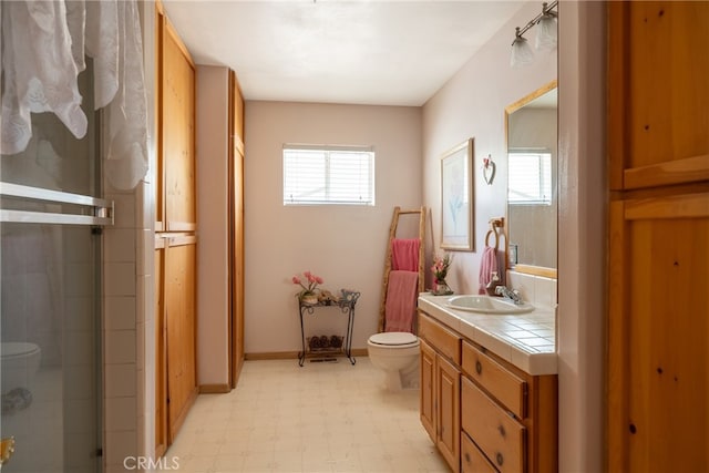 bathroom with vanity, toilet, and a shower with door