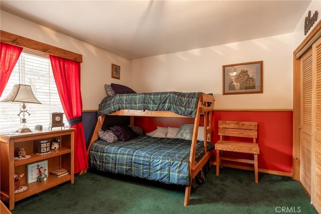 bedroom with dark colored carpet and a closet