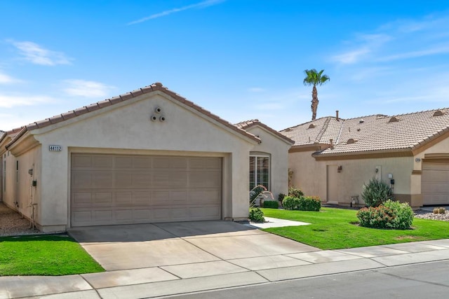 mediterranean / spanish-style house with a garage and a front lawn