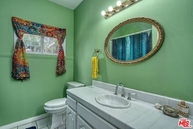 bathroom featuring toilet, vanity, and tile patterned flooring