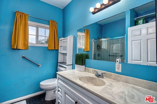 bathroom with vanity, hardwood / wood-style flooring, toilet, and walk in shower