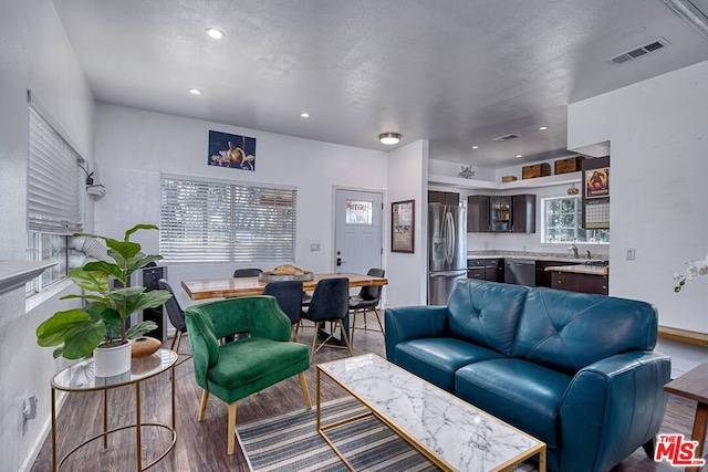 living room with a textured ceiling and wood-type flooring