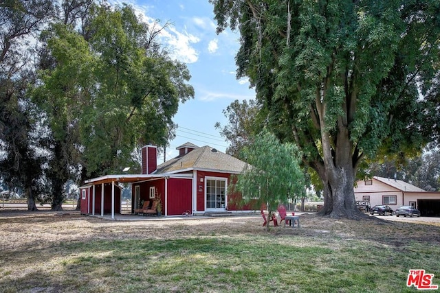 rear view of property with a lawn