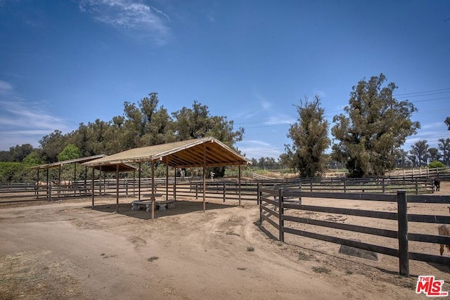 view of horse barn with a rural view