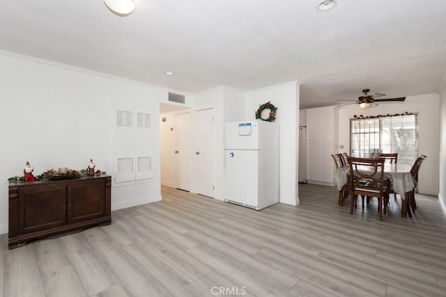 dining room featuring ceiling fan, ornamental molding, and light hardwood / wood-style flooring