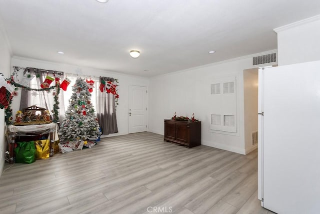 interior space with light wood-type flooring and ornamental molding