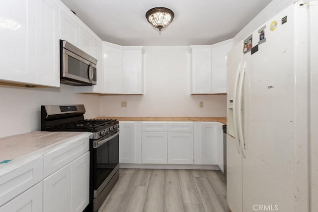 kitchen featuring white cabinets, light hardwood / wood-style flooring, and stainless steel appliances