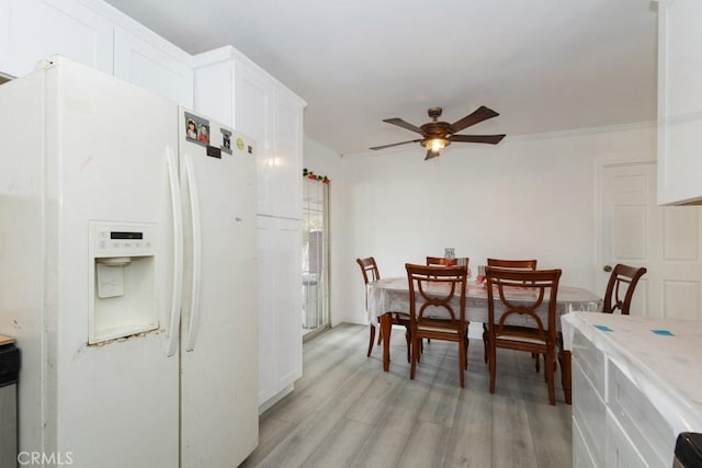 dining space featuring ceiling fan, crown molding, and light hardwood / wood-style flooring