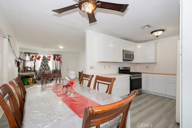 dining room with ceiling fan and light hardwood / wood-style flooring