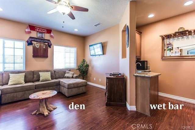 living room featuring ceiling fan, sink, and dark wood-type flooring