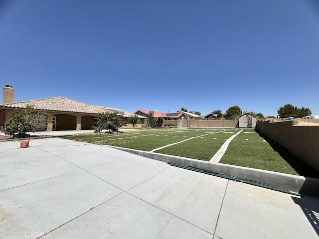 view of yard with a storage unit and a patio