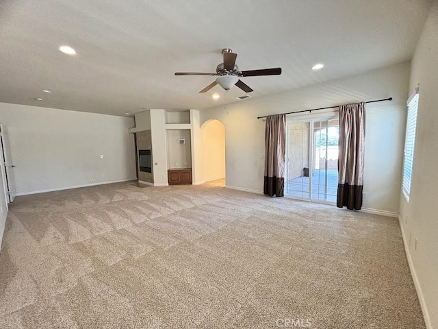 unfurnished living room featuring light carpet and ceiling fan