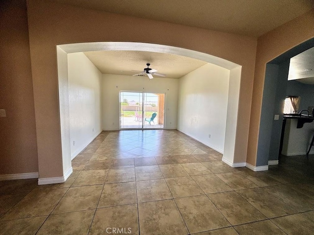 tiled spare room featuring a textured ceiling and ceiling fan