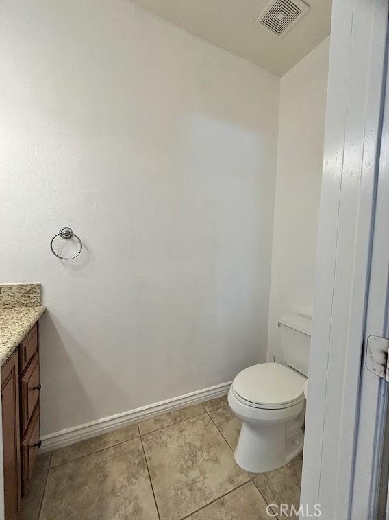 bathroom featuring tile patterned floors, vanity, and toilet