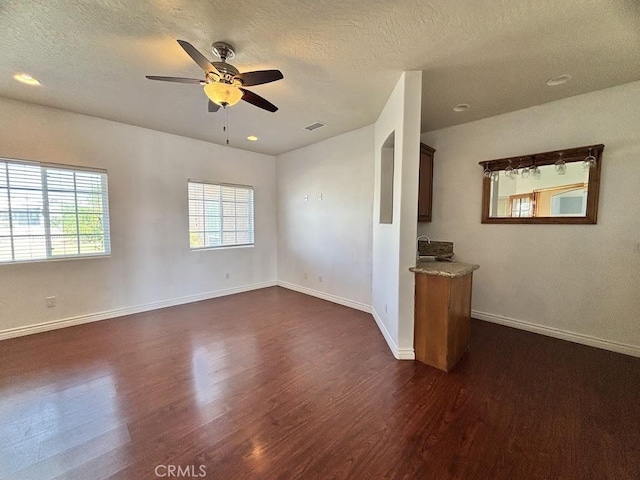 interior space with dark hardwood / wood-style floors, ceiling fan, and a textured ceiling