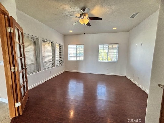 unfurnished room featuring ceiling fan, dark hardwood / wood-style flooring, and a textured ceiling