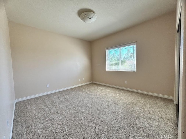 carpeted empty room with a textured ceiling