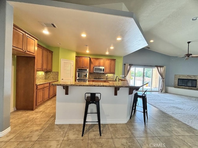 kitchen with a breakfast bar area, a kitchen island with sink, and stainless steel appliances