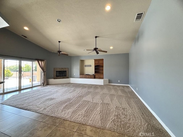 unfurnished living room with french doors, vaulted ceiling, ceiling fan, a textured ceiling, and light tile patterned flooring