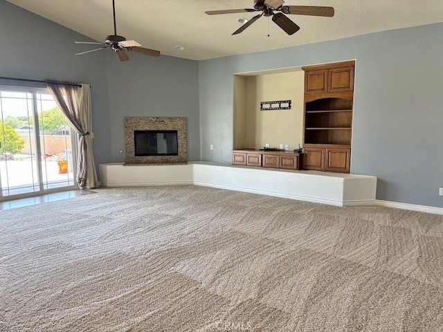 unfurnished living room featuring carpet flooring, lofted ceiling, ceiling fan, and a textured ceiling