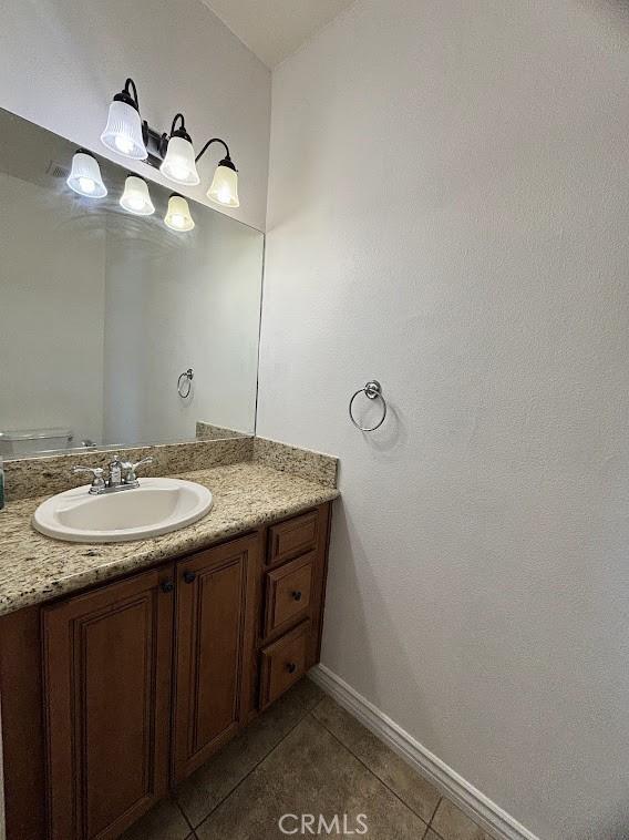 bathroom featuring tile patterned floors, vanity, and toilet