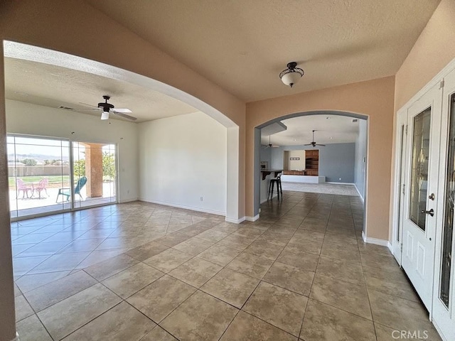 tiled spare room with ceiling fan and a textured ceiling