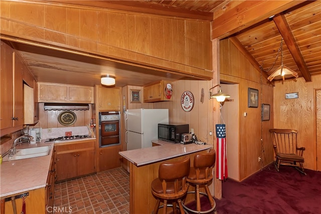 kitchen with kitchen peninsula, sink, black appliances, lofted ceiling with beams, and wooden ceiling