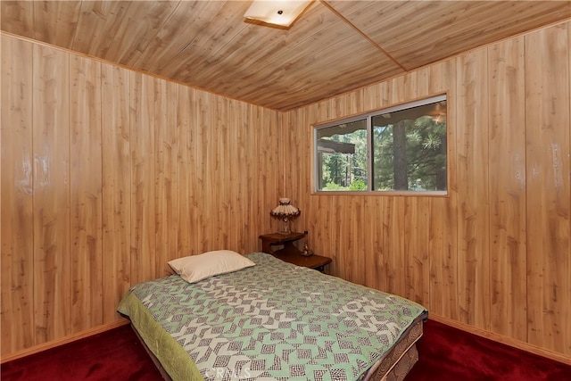 carpeted bedroom featuring wood ceiling and wooden walls