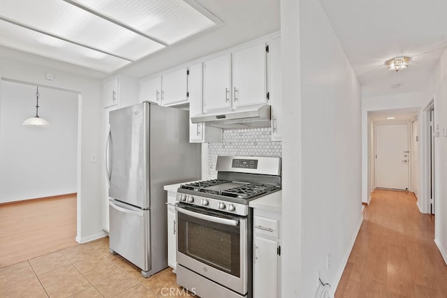 kitchen featuring white cabinets, tasteful backsplash, decorative light fixtures, stainless steel appliances, and light wood-type flooring