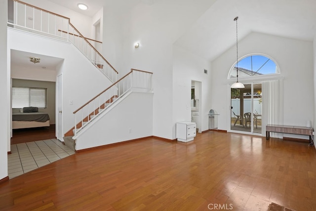 unfurnished living room with hardwood / wood-style flooring and high vaulted ceiling