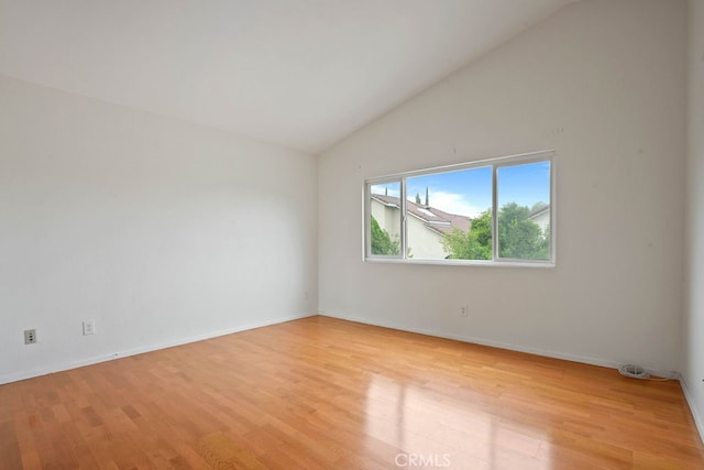 unfurnished room with light wood-type flooring and high vaulted ceiling