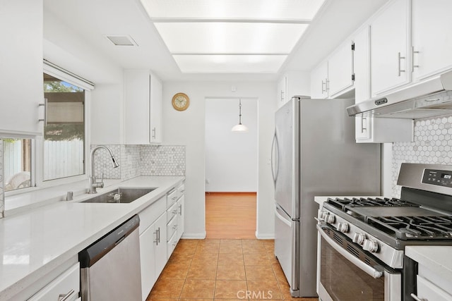 kitchen featuring hanging light fixtures, decorative backsplash, white cabinetry, stainless steel appliances, and sink